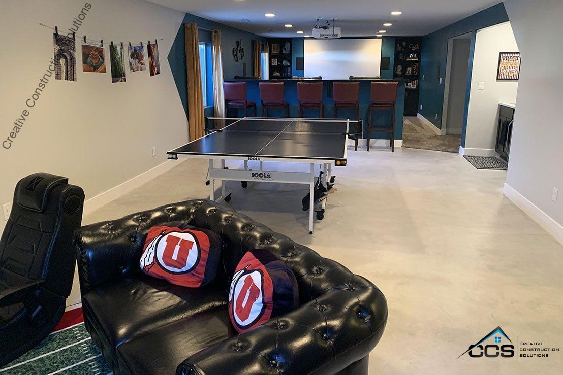 An image of a Utah finished basement. A logo for CCS Creative Construction Solutions of Utah is in the bottom right-hand corner.