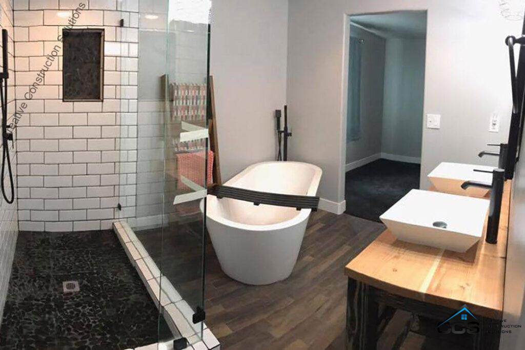 A modern bathroom featuring a stylish tub and a sleek shower, designed by Creative Construction Solutions.