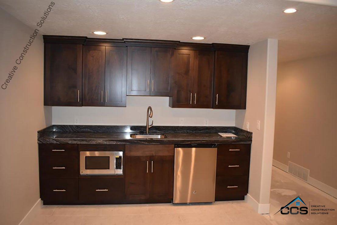An image of a Utah finished basement kitchenettes bars. A logo for CCS Creative Construction Solutions of Utah is in the bottom right-hand corner.
