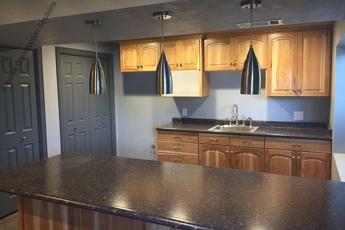 An image of a Utah finished basement kitchenettes bars. A logo for CCS Creative Construction Solutions of Utah is in the bottom right-hand corner.