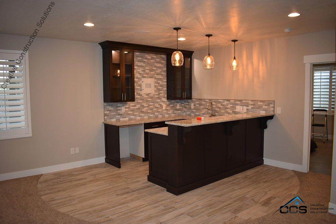 An image of a Utah finished basement kitchenettes bars. A logo for CCS Creative Construction Solutions of Utah is in the bottom right-hand corner.