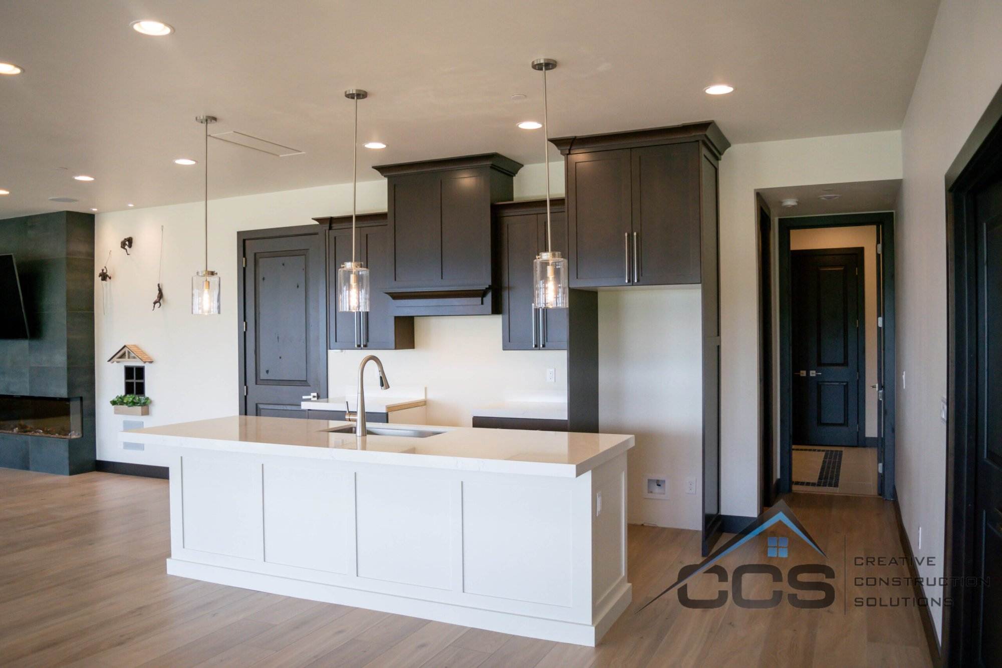 An image of a Utah basement kitchenette. A logo for CCS Creative Construction Solutions of Utah is in the bottom right-hand corner.