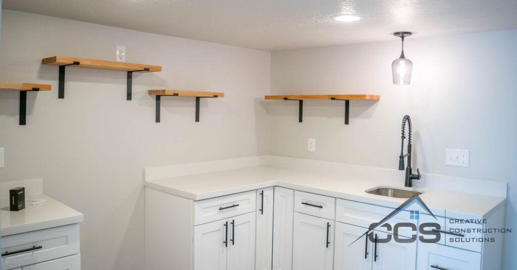 An image of a Utah basement kitchenette. A logo for CCS Creative Construction Solutions of Utah is in the bottom right-hand corner.