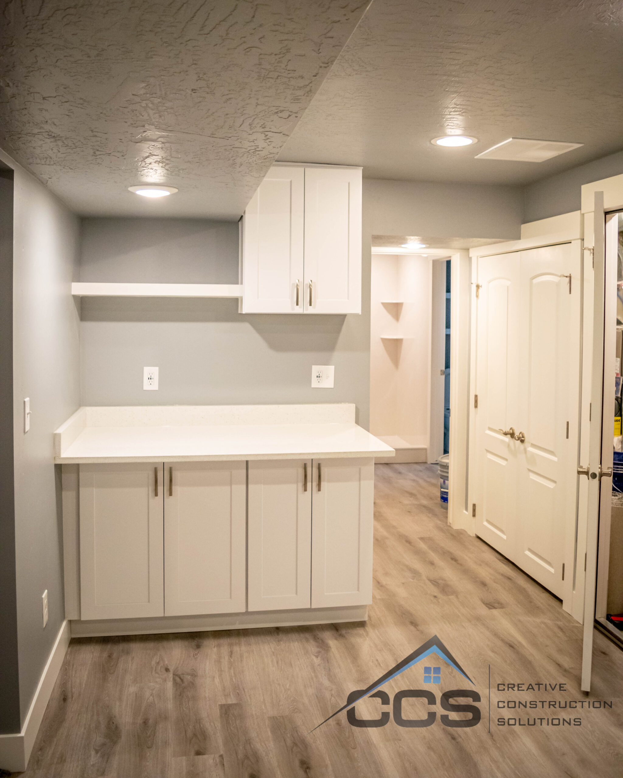 An image of a Utah basement kitchenette. A logo for CCS Creative Construction Solutions of Utah is in the bottom right-hand corner.