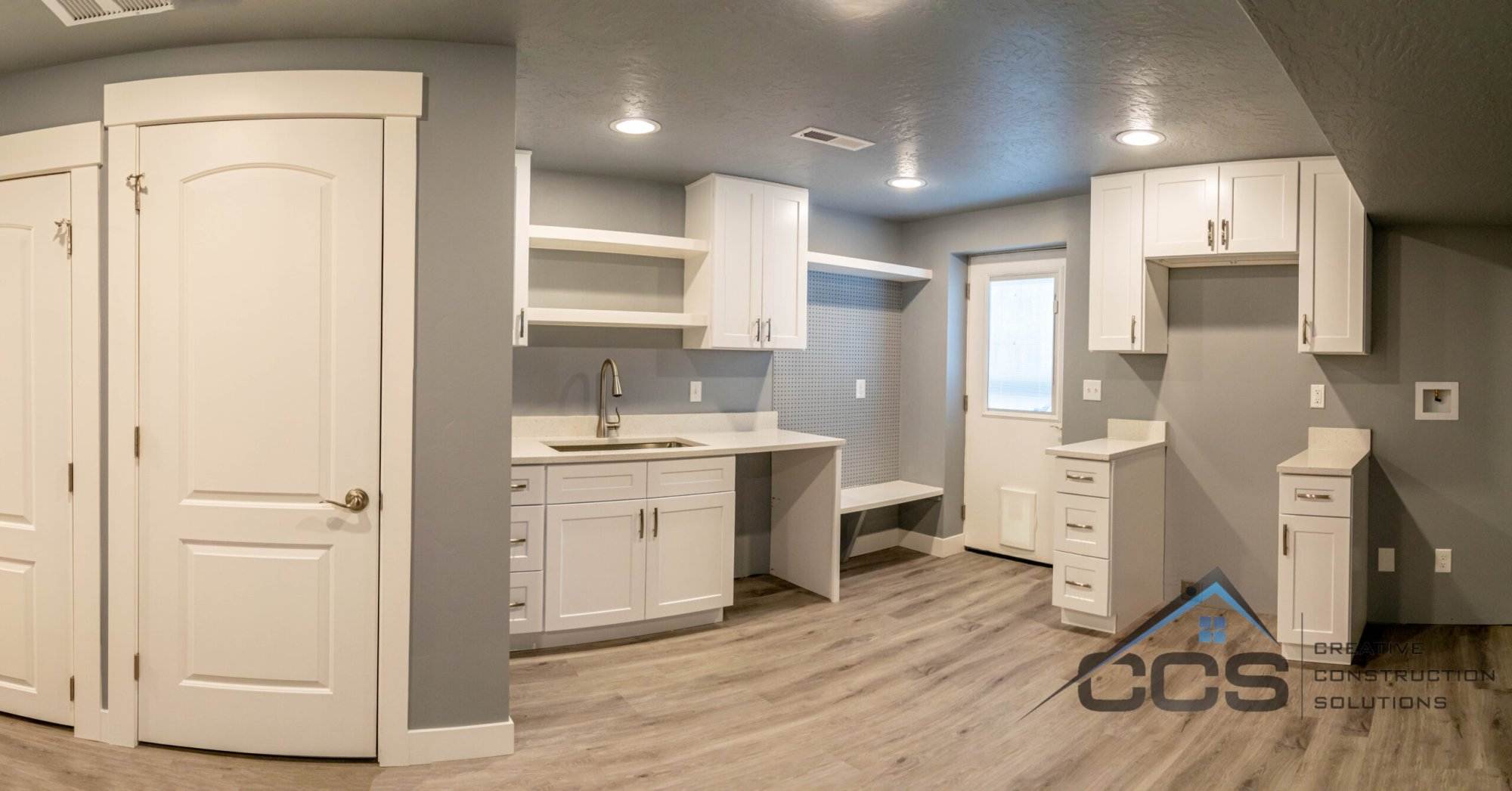 An image of a Utah basement kitchenette. A logo for CCS Creative Construction Solutions of Utah is in the bottom right-hand corner.