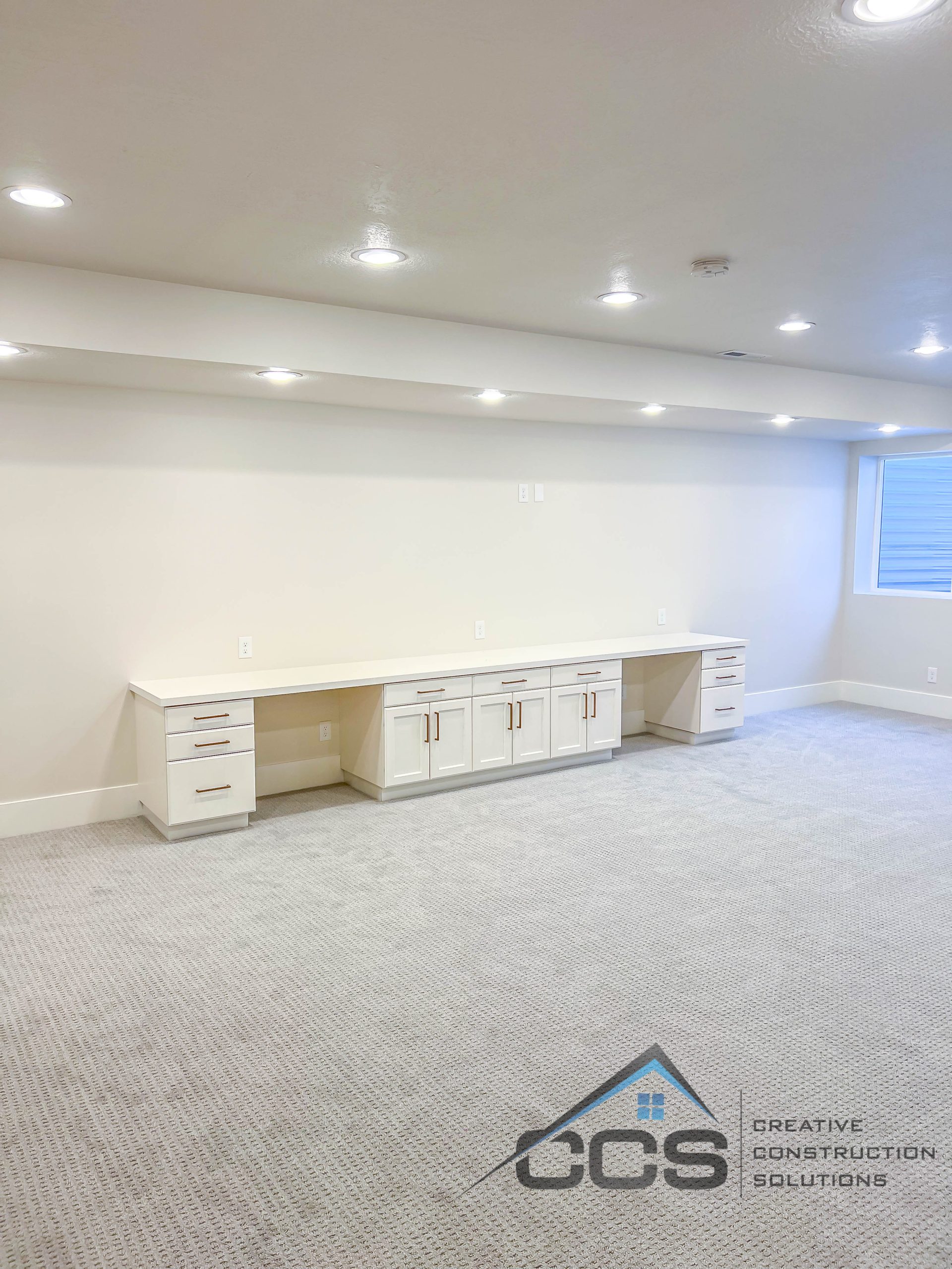 Bright finished basement in Utah with custom entertainment center.