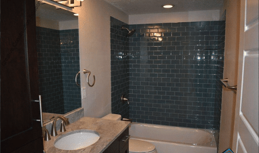 A modern bathroom with a sink, toilet, and shower.